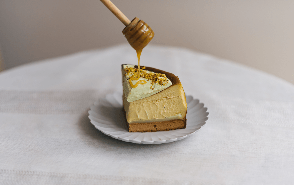 A slice of cheesecake drizzled in honey.