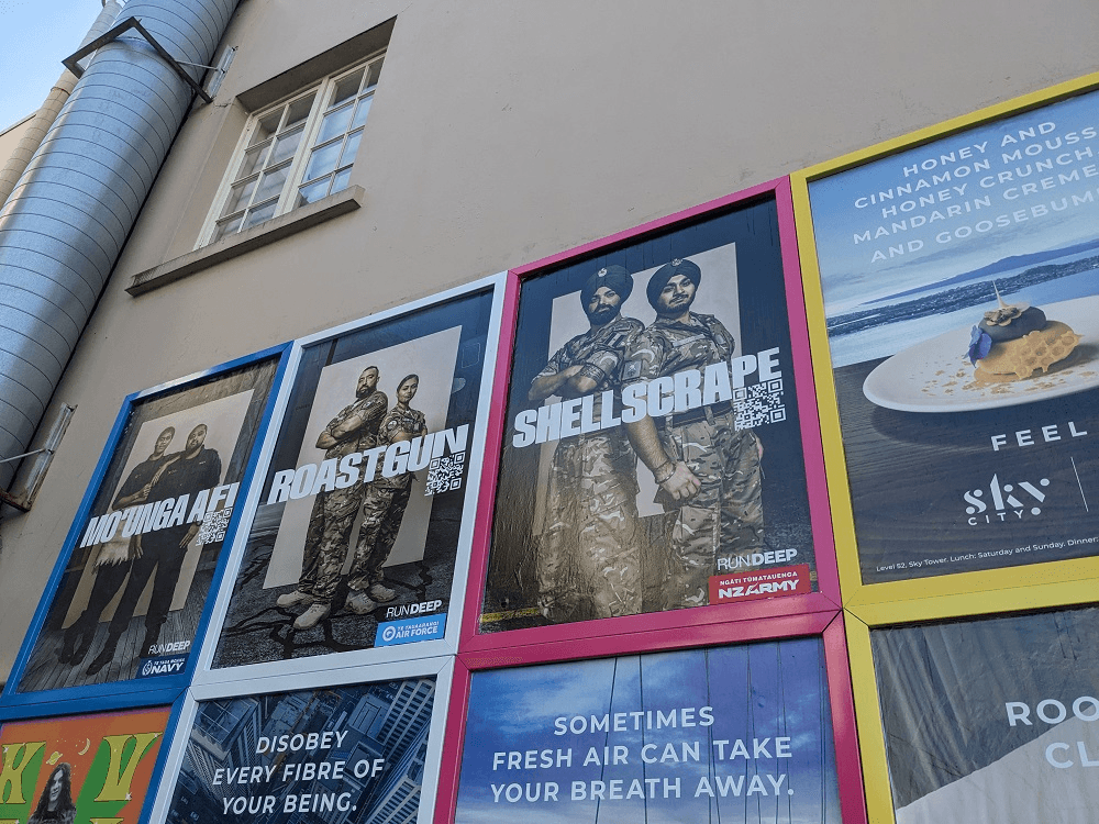 a beige wall with people in uiform for on posters for the code words campaign reading Shellscrape, roastgun, Mo'anga afi"
