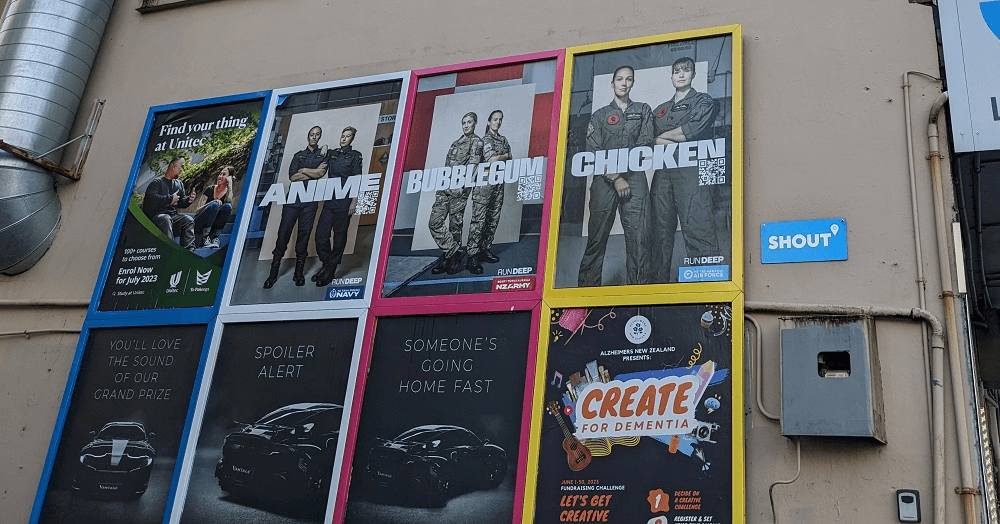 a beige wall with posters of two people in uniform and the words "anime" "chicken" and "bubblegum"