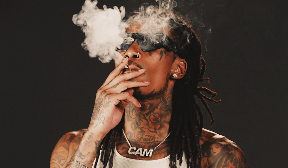 Wiz Khalifa smokes what appears to be a joint.