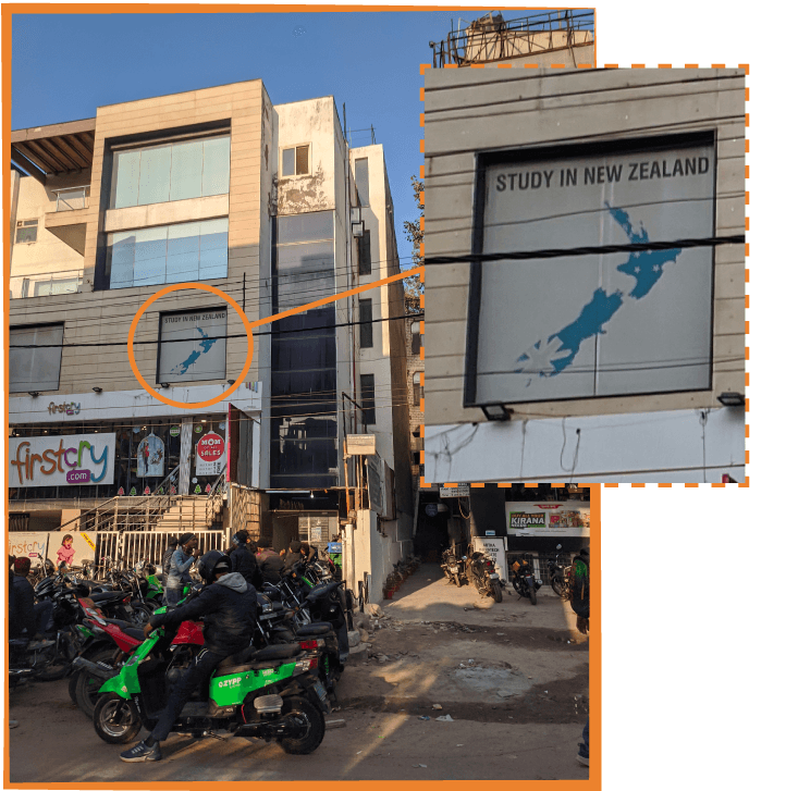a busy street in India with an advertisement in the window reading "study in New Zealand"
