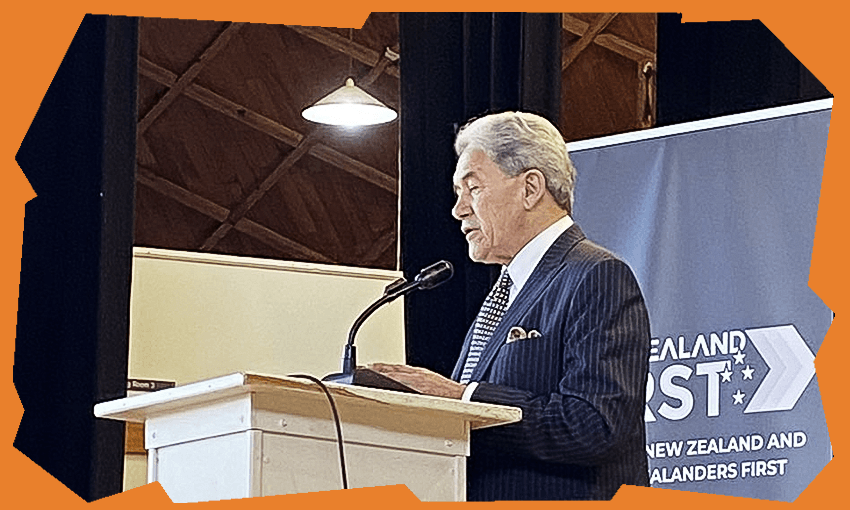 a side view of Winston Peters speaking into a microphone on a stage, with a NZ First banner behind him