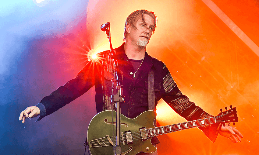 Josh Homme doing what he does best: on stage, playing guitar with Queens of the Stone Age.