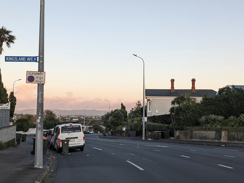 a road with a pinkish cloudy sky and the street stretching away