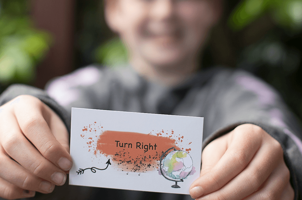 A child tries out the card game Getting Lost, which has told him to 'turn right'. 