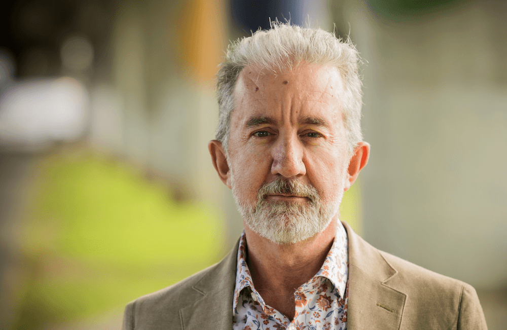 Nigel Latta with a jacket and grey hair.