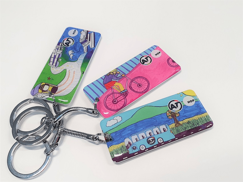 three plastic keytags with cool hand drawn designs by kids