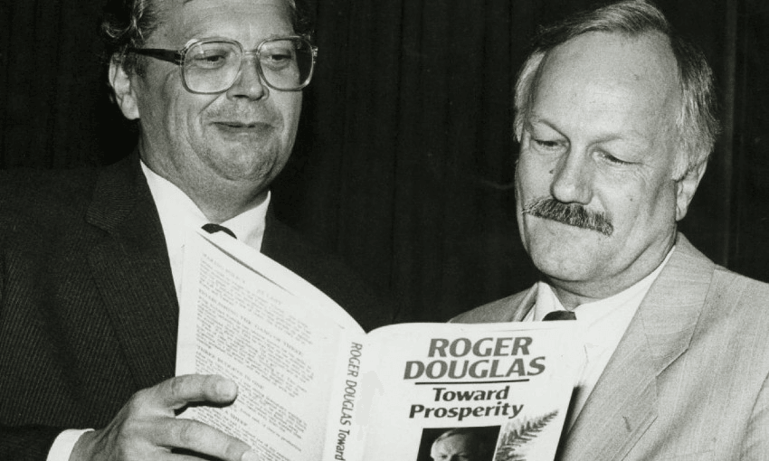 a greyscale photo of David lange, in glasses, next to a moustachioed roger douglas looking at a book 