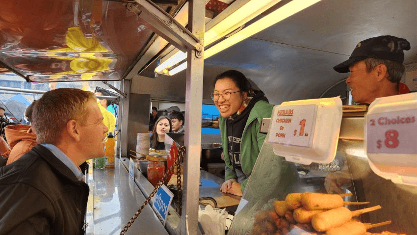 Chris Hipkins talking with Ōtara markets' vendor