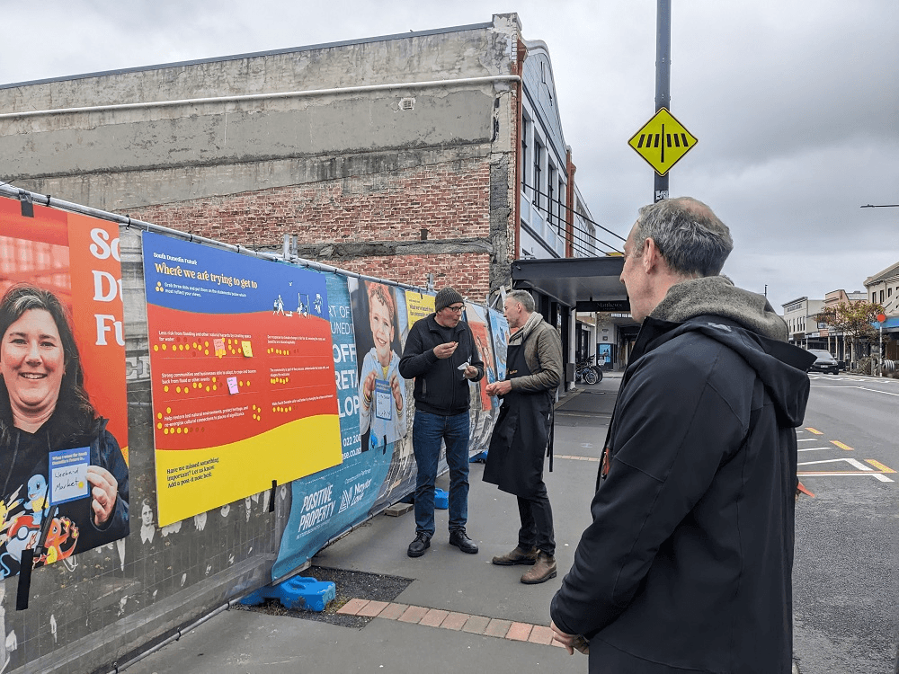 people look at sights with yellow stickers next to text on orange boards