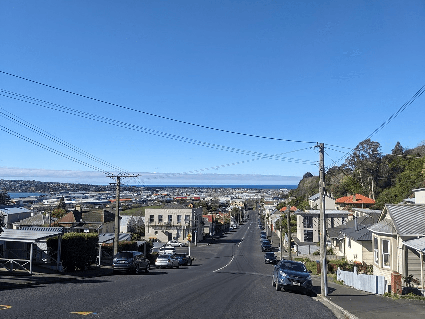 a blue sky and a road stretching to the ocean