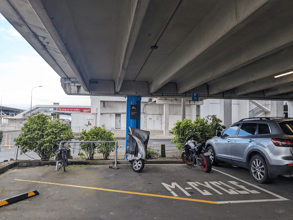 a carpark with a small bike rack and one bike surrounded by some motorbikes