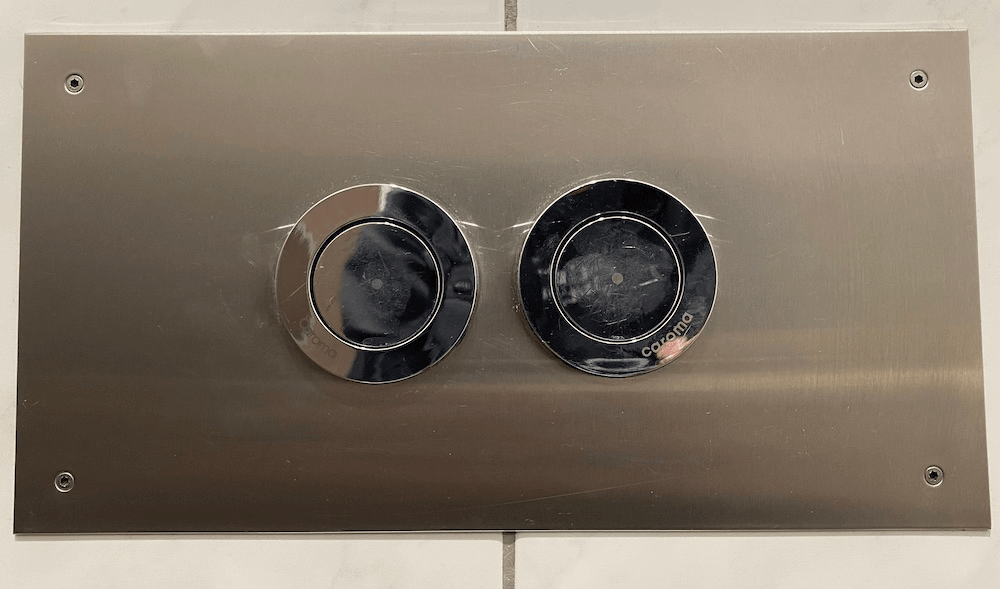 A New Zealand style toilet flush button.
