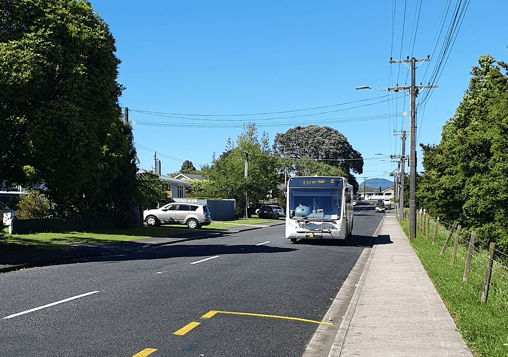 a bus going down a road with a blue sky