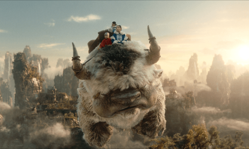A still shot from Netflix's live-action remake of Avatar The Last Airbender, showing the protagonists Aang, Katara and Sokka onboard a flying-bison.