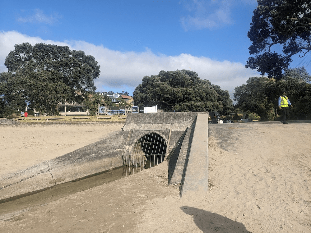 sandy beach with stream outlit and a grill