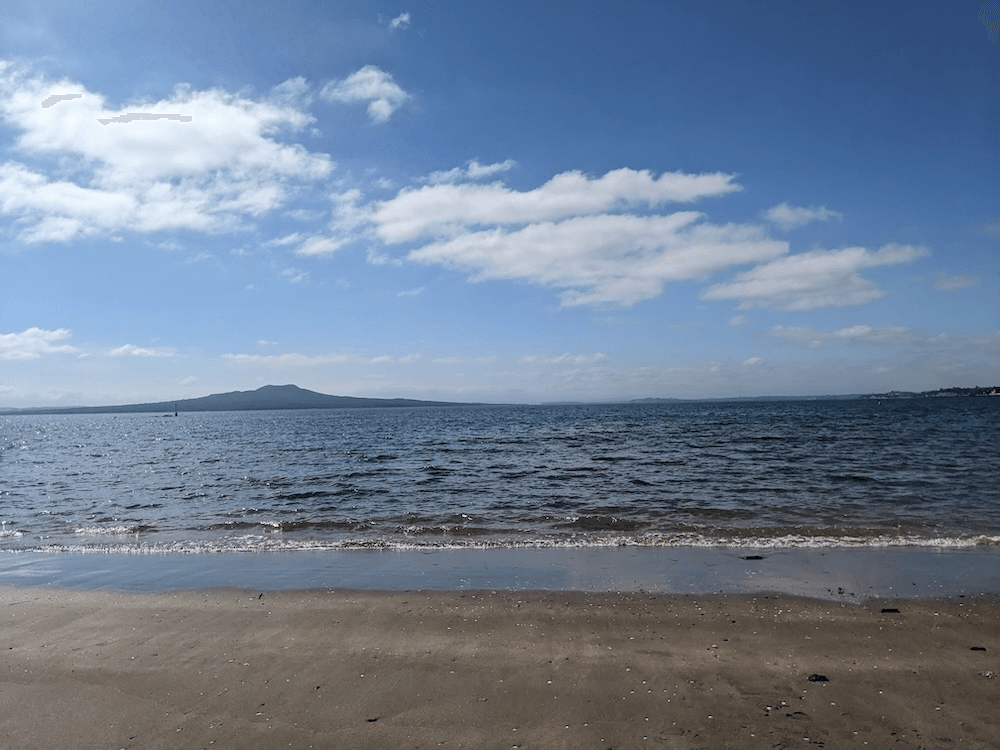 a beach with the shape of rangitot in the background