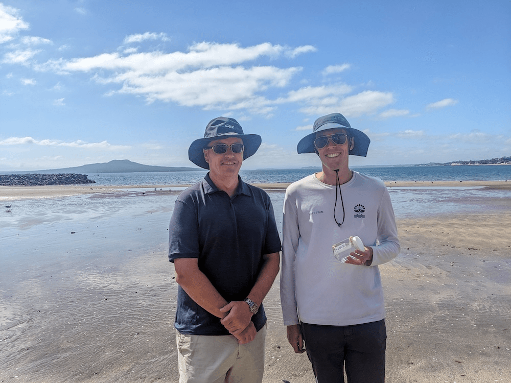 two white men wearing hats and sunglasses on a beach
