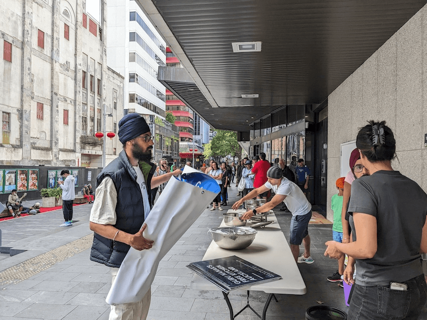 some volunteers setting up a table, grey toned building city scenes