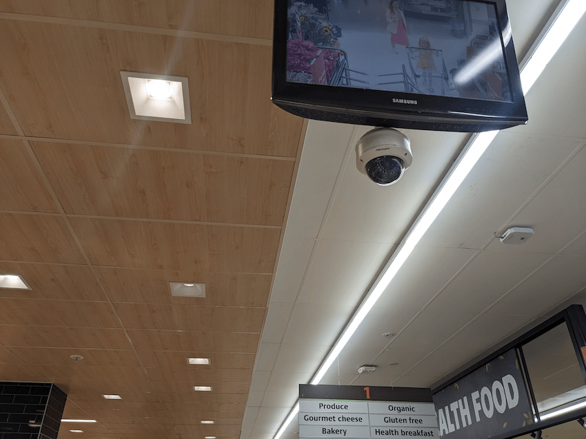a cctv camera on the ceiling of a supermarket