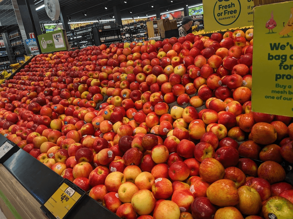 lts of apples that are red and yellow on shelves in a supermarket