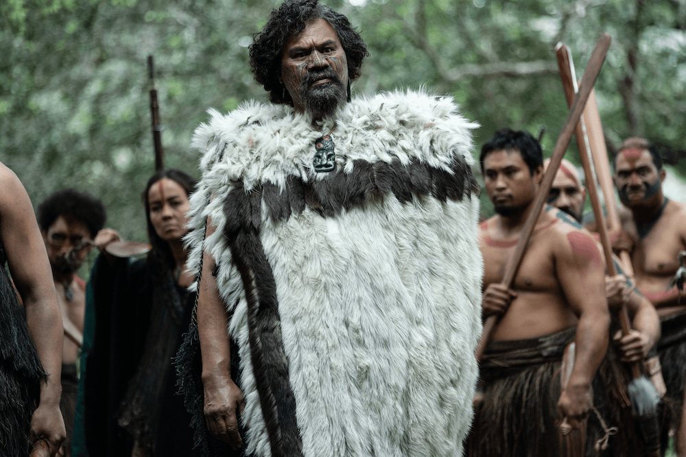Lawrence Makoare's character Akatārewa stands here in front of his taua (war party). He is one of the bilingual characters who act as translators between Māori and Pākehā.