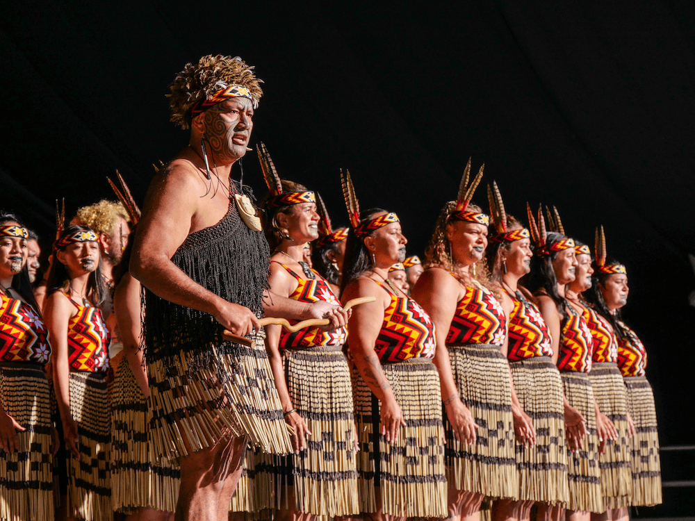 Te Pāti Māori leader Rawiri Waititi leads the Te Taumata o Apanui kapa haka group in their performance at the Mātaatua regional competition in late February 2024. They are adorned in traditional Māori dress.