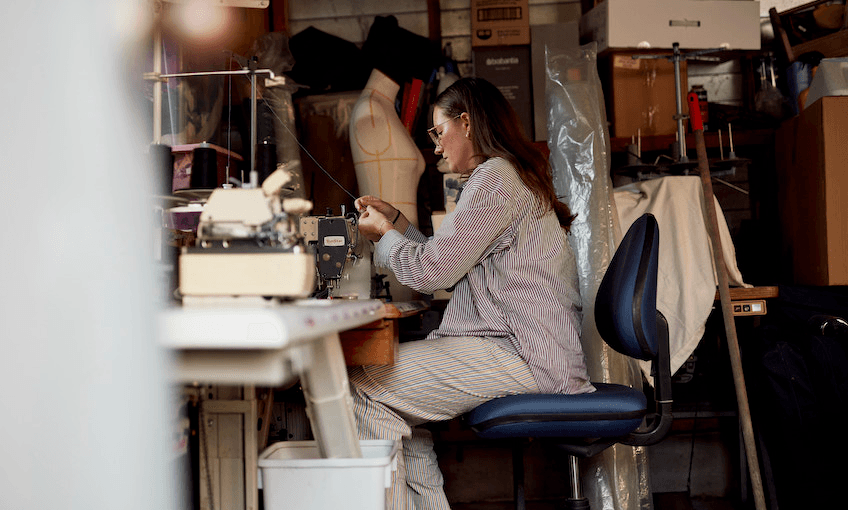 Whitney Barnes sits at her sewing machine making clothes in her garage. 