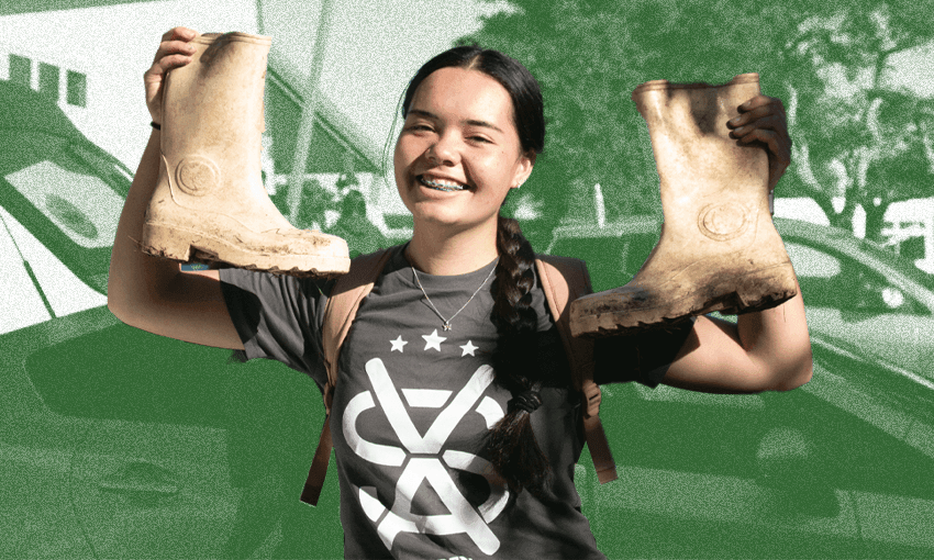 A high school volunteer wearing an SVA T-shirt holds up two gum boots and smiles.