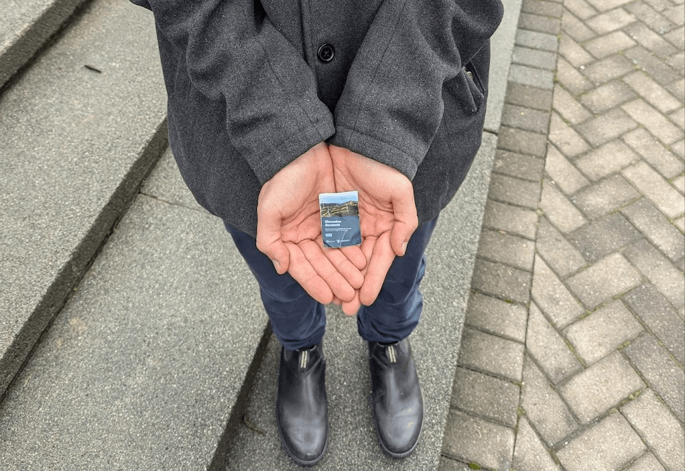 a white person's hand with a very small emissions reduction plan in it 