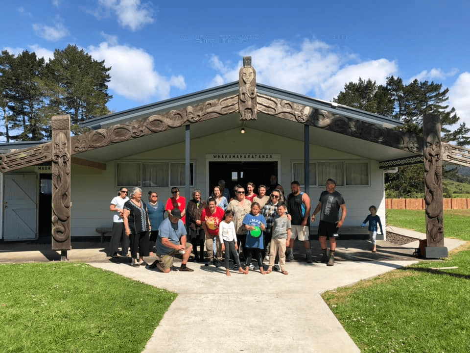 A group of people standing in front of a marae.