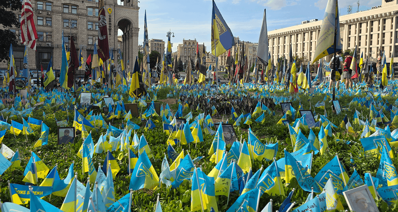 a courtyard filled with small blue and yellow flags in the sunshine