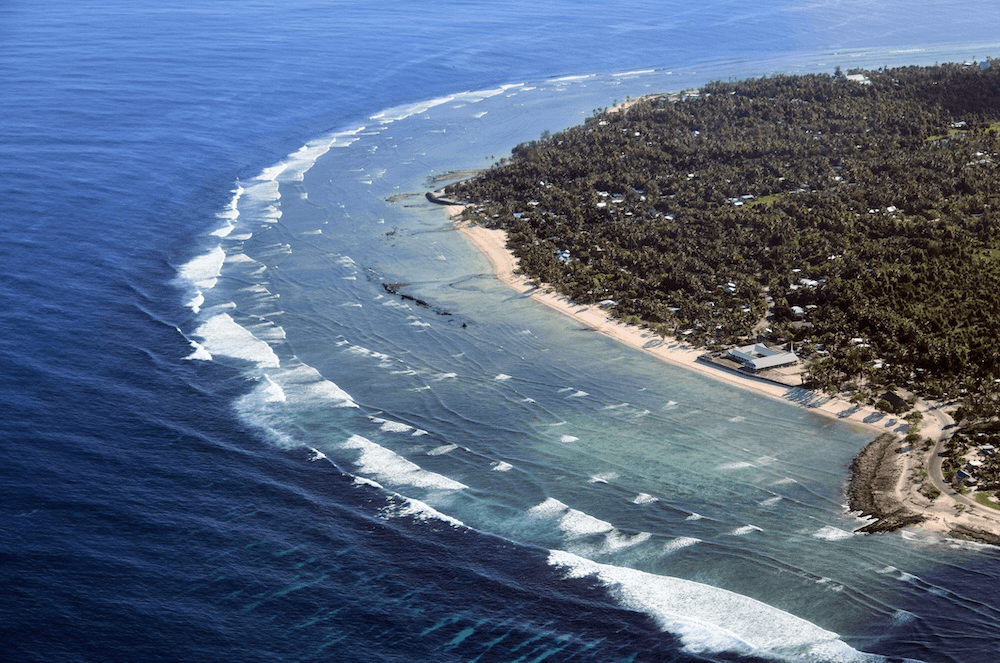 the corner of an island with waves and a big church