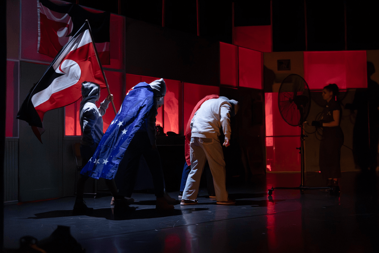 The opening scene of Ngā Rorirori featuring three people in grey hoodies wirth a dark background and the Tino Rangatiratanga, Cook Islands, and Samoan flags.