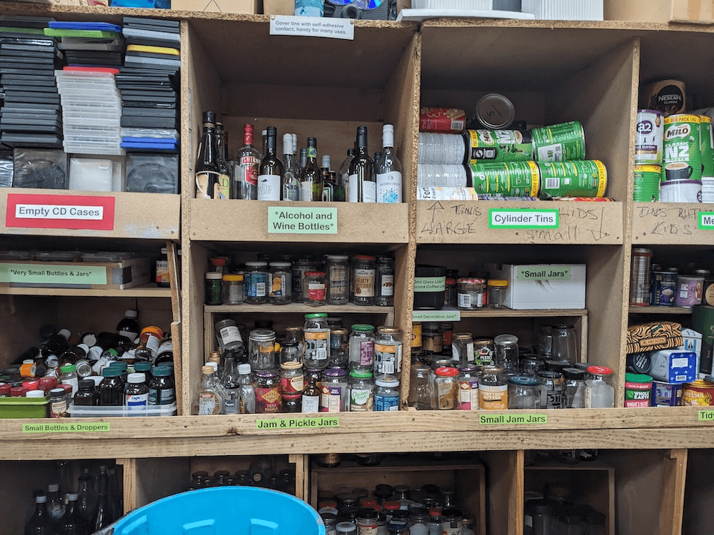 a shelf of empty jars and tins in various sizes, neatly labelled 