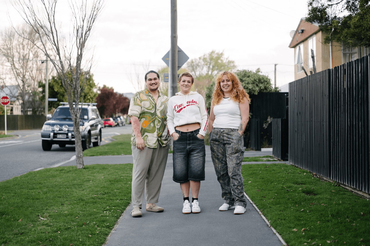 three people smiling on the footpath