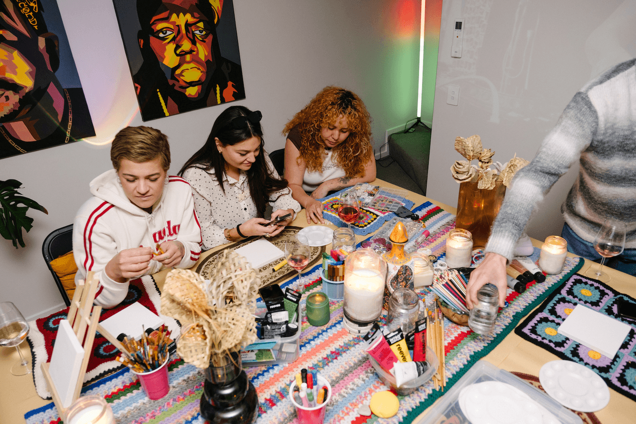 three people sitting at a table crafting