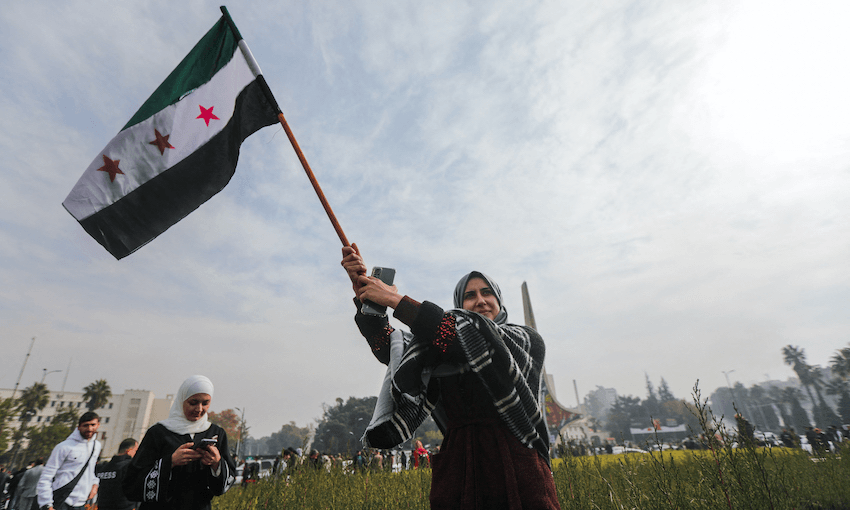 A woman waves a Syrian opposition flag as she celebrates at Umayyad Square in Damascus on December 8, 2024 (Photo: BAKR AL KASSEM/AFP via Getty Images)