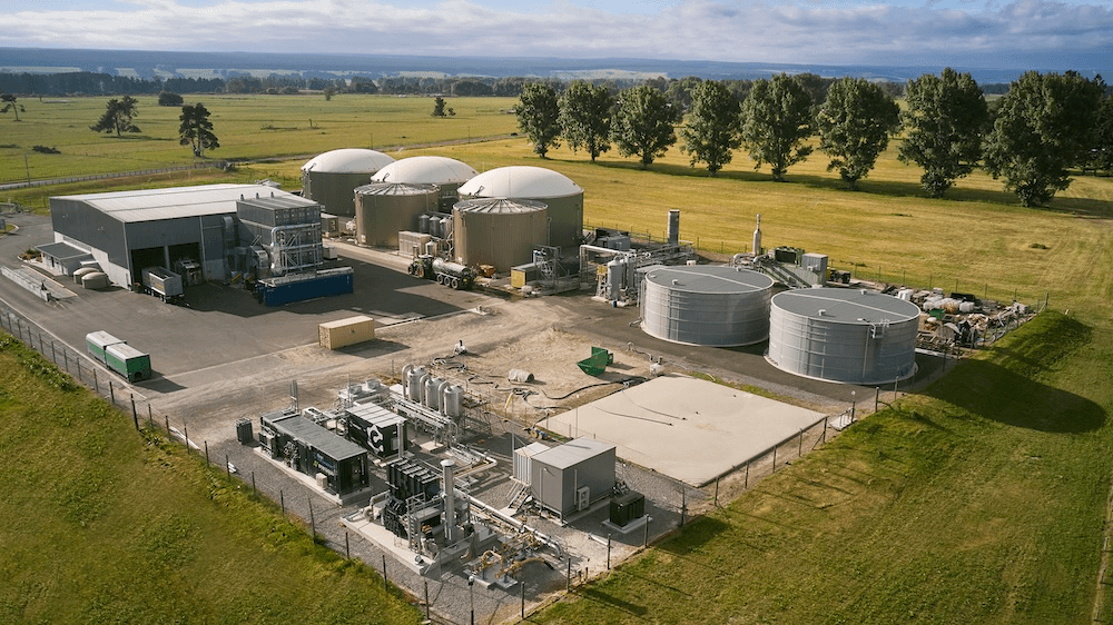 big green fields and poplar trees for windbreaks surround the series of spheres and rectangles that make up the reporoa plant on a sunny day