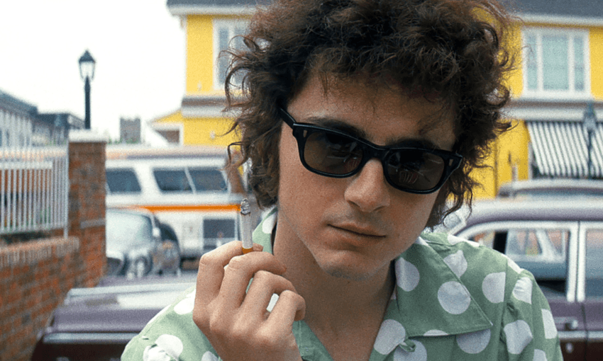 He has the hair, the sunnies, the cigarette and the hands. Timothée Chalamet as Bob Dylan in A Complete Unknown. Image: Macall Polay/Searchlight Pictures 
