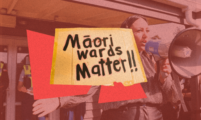 A person speaks into a megaphone during a protest, holding a sign that reads "Māori wards matter!!" The image is overlaid with red and yellow graphic elements.