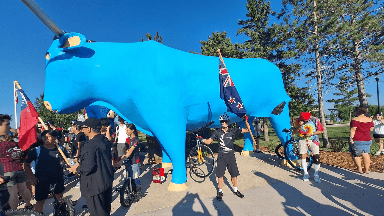 Ken Looi carrying the New Zealand flag at the 2024 unicycling world championships in Minnesota, USA