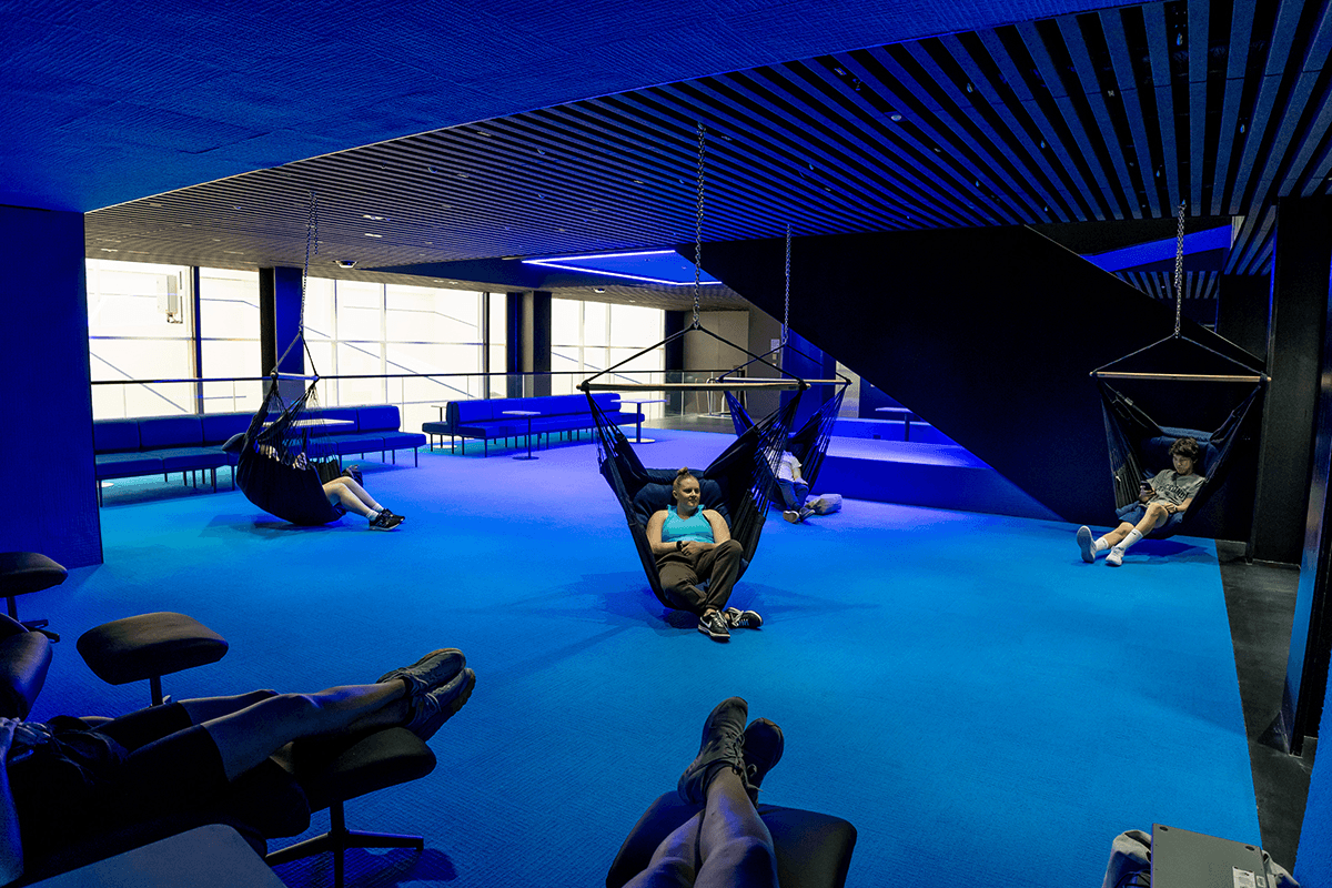 blue lit room with hammock and couches