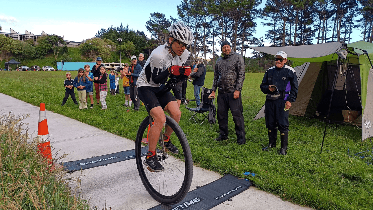 Ken Looi at the moment he broke the 24 hour world record. Crossing the finish line. Supporters look on proudly. 