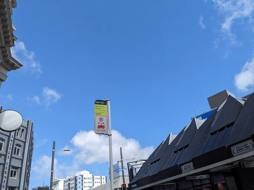 a blue sky and a bus stop sign