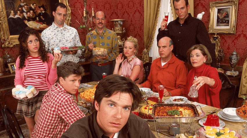 A family sit around a dining table various vacant expressions