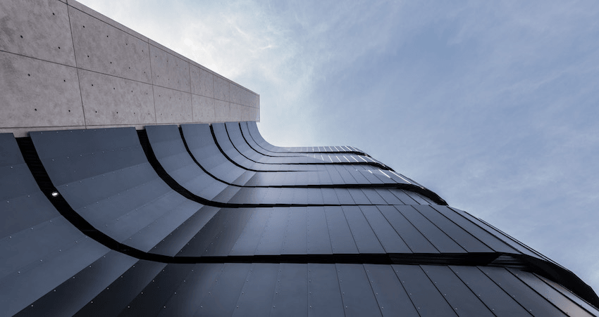 Swooping black eel shaped panels on the side of a building