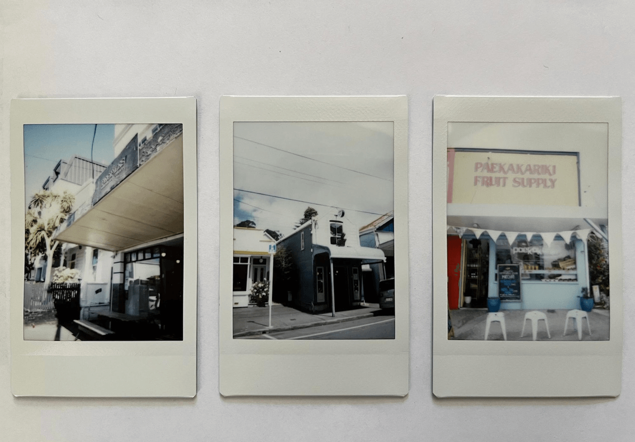 Three polaroids: The first photo features a building with a black balcony, the second, and the third shows a fruit supply store with a pink sign reading 'Paekakakariki fruit supply'