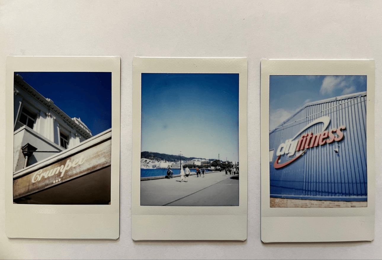 Three Polaroid photos: first shows part of a building with the word "Crumpler," second displays a seaside promenade with people walking, and third features a building with "City Fitness" on it, against a blue sky.