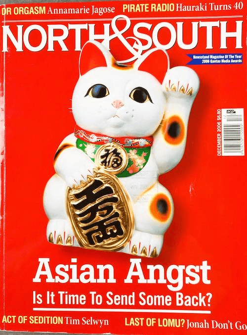 a bright red North & South magazine cover with a large lucky cat in the centre. Feature headline reads “Asian Angst - Is it time to send some back?”.